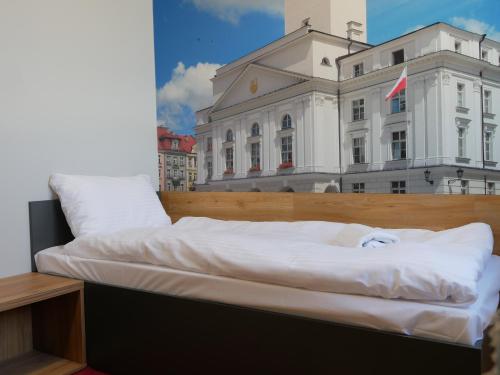 a large white bed sitting on top of a building at blue hotel in Kalisz