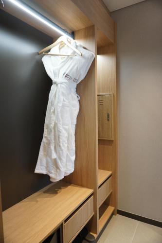a white dress is hanging in a closet at Wirye Militopia Hotel By Marine in Seongnam