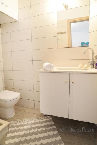 a bathroom with a sink and a toilet at Avra Studios in Masouri