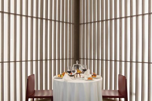 a table with two chairs and a white table with wine glasses at Melas Hotel Istanbul in Istanbul