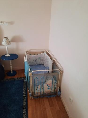 a crib in a room with a table and a lamp at Le Faidherbe in Albert