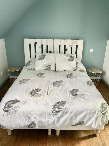 - un lit avec une couette et des oreillers blancs dans l'établissement Gîte les Retrouvailles, à Saint-Quentin-Lamotte-Croix-au-Bailly