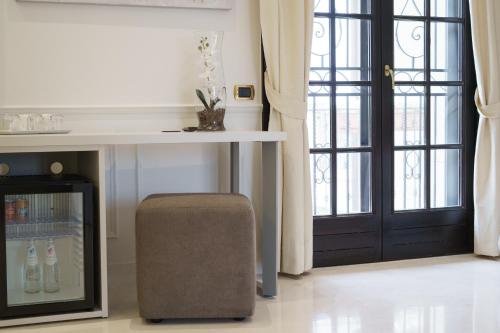 a room with a table and a stool next to a door at Caffetteria Luca Suite & Rooms in Bronte