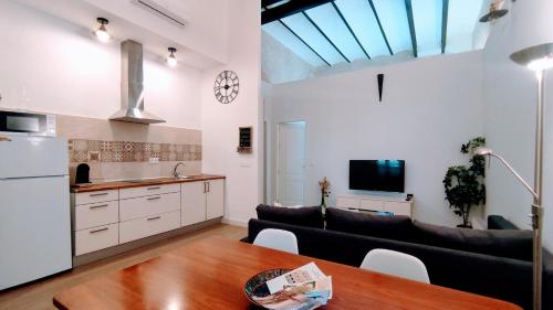 cocina y sala de estar con sofá y mesa en Miraflores 58 Apt - Private Parking Opt, en Sevilla