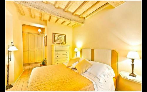 a bedroom with a yellow bed with two lamps at la locanda di anita in Cetona