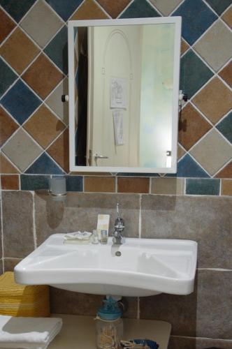 a bathroom with a white sink and a mirror at Hotel Sa Cralla Villasimius in Villasimius