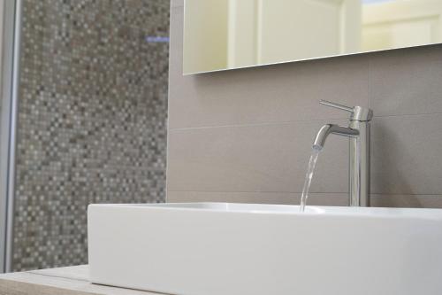 a white sink with a faucet in a bathroom at Caffetteria Luca Suite & Rooms in Bronte