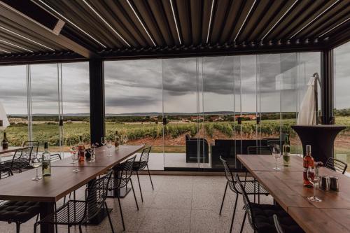 a room with tables and chairs and a large window at Dobosi Birtokközpont in Szentantalfa