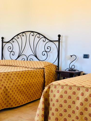 a bedroom with two beds with yellow and red sheets at Casale Viridi - nel fresco delle colline Umbre in Narni
