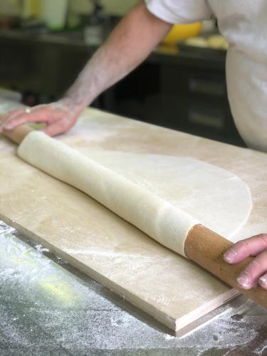 a man rolling out dough on a cutting board at Casale Viridi - nel fresco delle colline Umbre in Narni