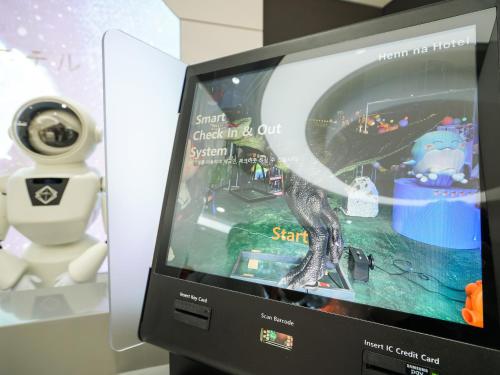a tv with a dinosaur on it next to a robot at Henn na Hotel Seoul Myeongdong in Seoul