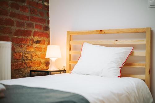 a bedroom with a white bed and a brick wall at Kali Host Home Away From Home in Târgu-Mureş