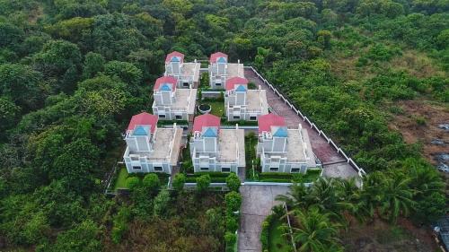 an aerial view of a large house in the forest at The Blue View - sea view villas in Ratnagiri