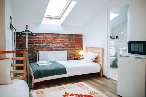 a bedroom with a bed and a brick wall at Kali Host Home Away From Home in Târgu-Mureş