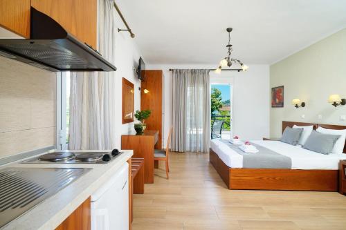 a hotel room with a bed and a kitchen at Antigone Thassos Hotel in Limenas
