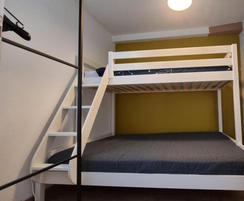 Ce lit superposé se trouve dans un dortoir avec une échelle et un lit superposé dans une mezzanine. dans l'établissement Appartement magnifique vue Mer tout confort, au Cap d'Agde