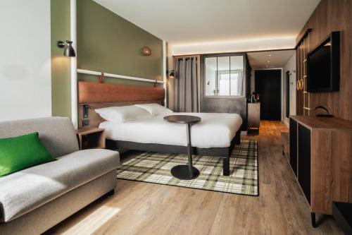 a hotel room with a bed and a couch at ibis Styles Castelnaudary in Castelnaudary