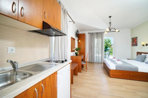 a kitchen with a sink and a bed in a room at Antigone Thassos Hotel in Limenas