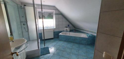 uma casa de banho com um chuveiro, uma banheira e um lavatório. em Ferienwohnung-in-Mecklenburg-am-Kritzower-See-mit-Ruderboot em Kritzow