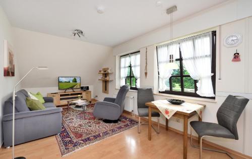 uma sala de estar com um sofá, cadeiras e uma mesa em Haus Sigge Ferienwohnungen em Bad Sassendorf