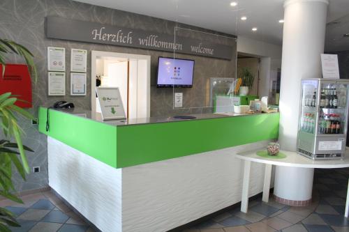 een groene en witte toonbank in een winkel bij H+ Hotel Erfurt in Erfurt