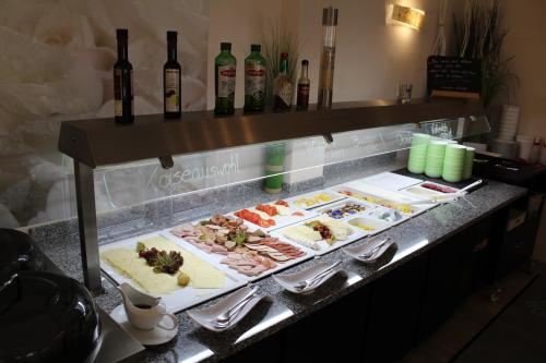 - un buffet composé de différents types de nourriture et de bouteilles de vin dans l'établissement H+ Hotel Erfurt, à Erfurt