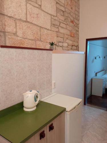 a kitchen with a green counter and a refrigerator at Rooms Zela 1 in Korčula