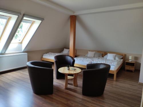 a room with a bed and two chairs and a table at Miklós Fogadó és Étterem in Mátraterenye
