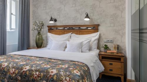 a bedroom with a large bed with a wooden headboard at Monastery Garden Prague in Prague