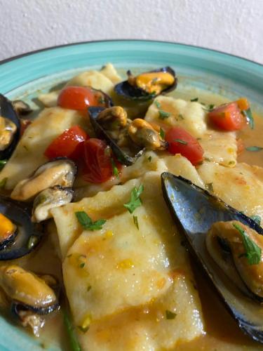 a blue plate of food with mushrooms and tomatoes at Agriturismo S´Aranada in Marrùbiu