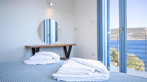 a bedroom with a bed with a mirror and a balcony at Akasha Suite IV in Vathi