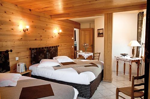 - une chambre avec 2 lits dans une pièce dotée de murs en bois dans l'établissement La Passerelle chambre au calme proche la Clusaz et Grand Bornand, à Saint-Jean-de-Sixt