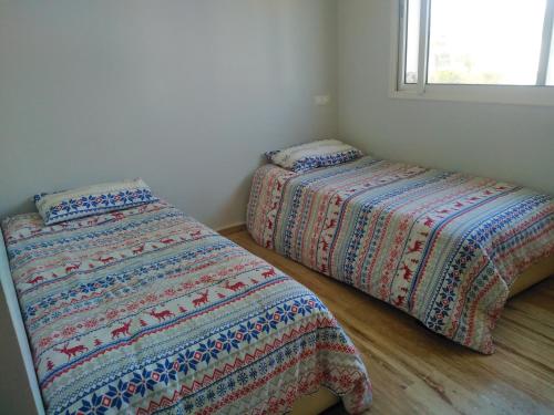 dos camas sentadas una al lado de la otra en un dormitorio en Bel Appartement à PUERTO MARINA-DAR BOUAZZA avec piscines et jardins, en Casablanca