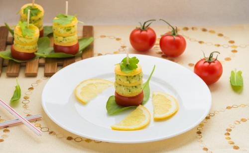 a white plate with food on a table with tomatoes at Hotel Schönegg in Seefeld in Tirol