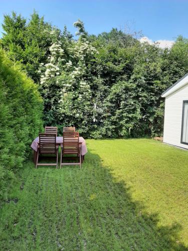 drie stoelen en een tafel in een tuin bij De Woudtplaats in Wolfheze