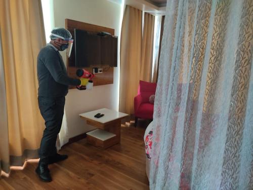 a man wearing a mask standing in a hotel room at Abhilashi Residency & Spa - Centrally Heated & Air Cooled in Manāli