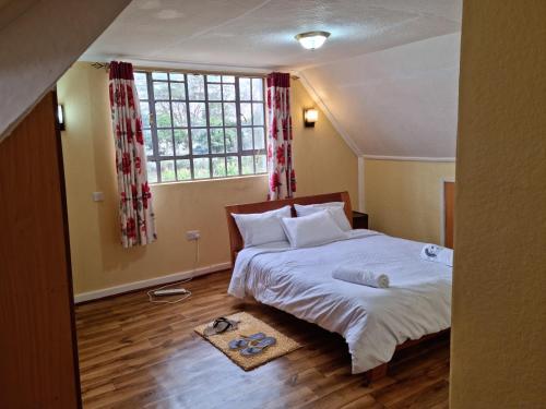 a bedroom with a bed and a large window at Weavers Haven in Naivasha