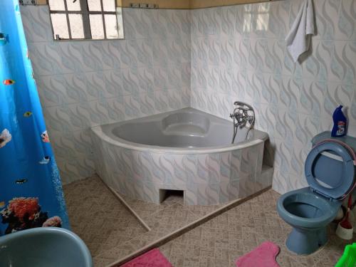 a bathroom with a bath tub and a toilet at Weavers Haven in Naivasha