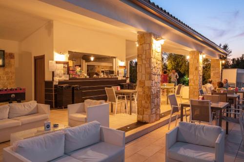 a patio with couches and tables and a restaurant at Residence Gli Stingi in Vieste