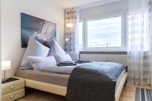 Schlafzimmer mit einem Bett und einem großen Fenster in der Unterkunft Auszeit Apartment DOWNTOWN im Herzen der Innenstadt - am Hafen und am Bodenseeradweg - schnelles Internet, für bis zu 2 Personen in Friedrichshafen