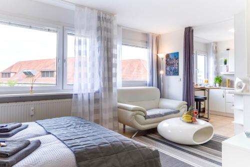 ein Schlafzimmer mit einem Bett, einem Stuhl und einem Fenster in der Unterkunft Auszeit Apartment DOWNTOWN im Herzen der Innenstadt - am Hafen und am Bodenseeradweg - schnelles Internet, für bis zu 2 Personen in Friedrichshafen