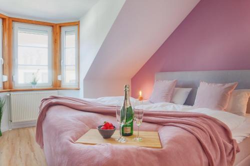 Schlafzimmer mit einem Bett mit einer Flasche Champagner und einer Kerze in der Unterkunft Sünnhus in Heiligenhafen