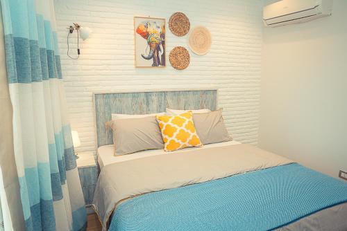 a small bedroom with a bed with a blue and white at Porto Golf Marina in El Alamein