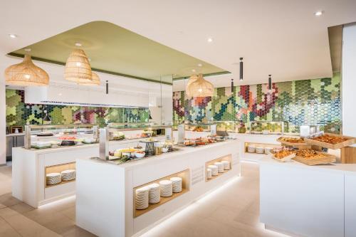 a restaurant with white counters with food on display at Barceló Conil Playa - Adults Recommended in Conil de la Frontera