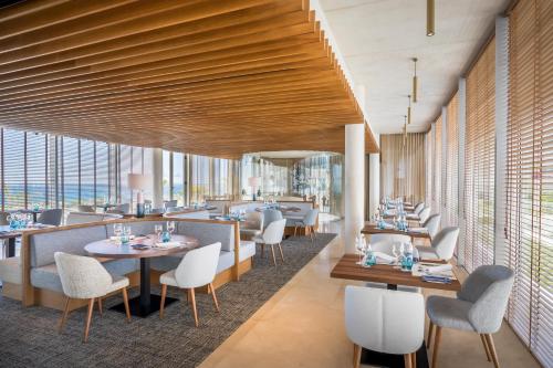 a restaurant with wooden ceilings and tables and chairs at Barceló Conil Playa - Adults Recommended in Conil de la Frontera
