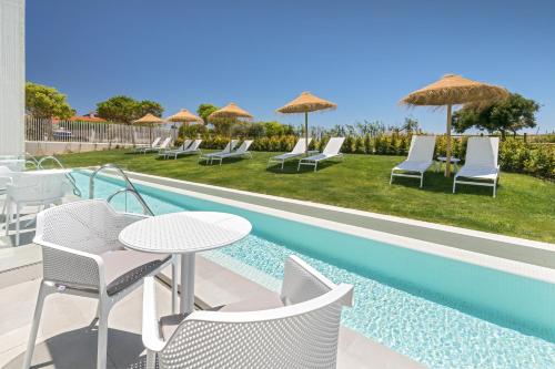 a patio with a table and chairs next to a pool at Barceló Conil Playa - Adults Recommended in Conil de la Frontera