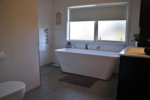 a white bath tub in a bathroom with a window at The Country Escape in Fernhill
