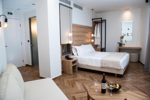 a hotel room with two beds and a table with a bottle of wine at Liberty of Nafplio in Nafplio