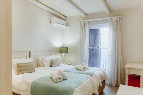 two beds in a bedroom with a window at Phoenix 1 in Paternoster