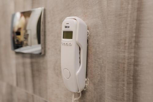 a white soap dispenser on a wall with a mirror at Lot Boutique Hotel by Hotels and Preference in Tirana